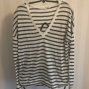Randig tröja från Tally Weil - Säljer en snygg och bekväm randig tröja från Tally Weil  i storlek M.Den är vit med blåa ränder och har en v-ringad hals. Perfekt för en avslappnad stil och passar bra till både jeans och kjol. Tröjan är långärmad och i bra skick.