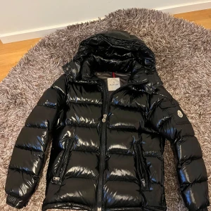 Moncler maya  - Säljer nu min moncler jacka, har endast använt den under en vinter. Det är storlek 2 på den vilket motsvarar M. Passar även S. De enda ”bristerna” jackan har är snöret på bild 3 och serien som har tappat lite färg. Den är även identisk till en äkta.