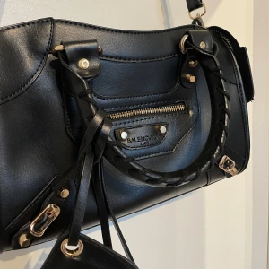 Svart väska med gulddetaljer🖤 - Super snygg och trendig väska. Den är sparsamt använd få gånger som man ser på bilderna. Måtten är 28,5 x 19 cm. Alltså är den väldigt rymlig.😊