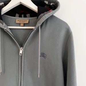 Burberry zip Hoodie  - Burberry zip Hoodie i topp skick, just denna färgen på burberry hoodies är rätt svår att få tag i och är i färgen babyblå/grå!  St M passar även s, vid minsta fundering bara hör av dig!