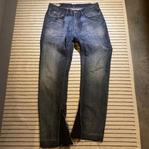 Mörkblåa Jeans - Sjuka jeans som är custom made! Flare på ändarna och lite slitningar. Även nitar på högra framfickan!! Midja 40 cm. Innerbenslängd 77 cm. För mer funderingar skriv gärna!!