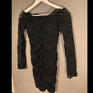 Svart spetsklänning - Snygg svart offshoulder klänning i spets med långärmad design. Perfekt för festliga tillfällen med sin eleganta och stilrena look. Klänningen har en åtsittande passform och vacker rynkdetalj framtill och likadan baktill som ger en smickrande silhuett. 🖤 (PM OM DU VILL HA FLER BILDER)