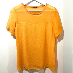 Gul kortärmad topp från Zara - Snygg gul topp från Zara i ett lätt och luftigt material. Perfekt för sommardagar med sin kortärmade design och enkla stil. Toppen har en rund halsringning och är i mycket bra skick. Passar både till vardags och festliga tillfällen.