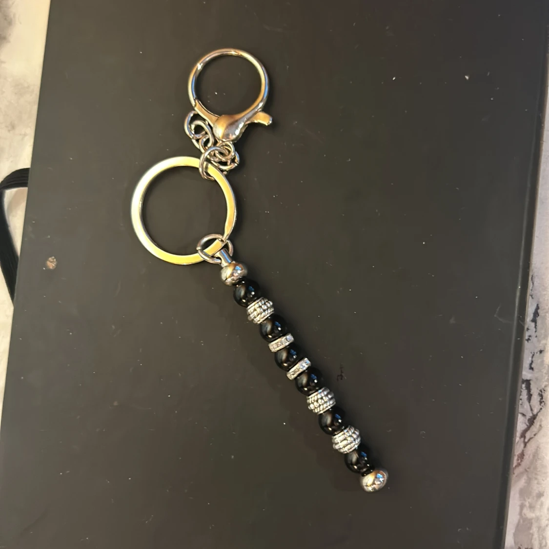 Nyckelring med svarta och silverfärgade pärlor