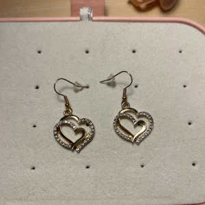 Guldiga Hjärt örhängen  - Jättefina guldiga hjärt örhängen med stenar. Oanvända💕