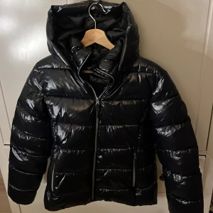 Svart glansig dunjacka - Säljer en super snygg glansig vinter jacka!! Använd ungefär 5 gånger så i väldigt bra skick! 💕den är i barn storlek men passar bra som s/xs 💕