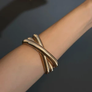 Guldarmband i spiraldesign - Snyggt guldarmband med en unik spiraldesign som ger en modern och elegant look. Perfekt för att lyfta vilken outfit som helst, oavsett om det är till vardags eller fest. Armbandet är flexibelt och bekvämt att bära hela dagen.