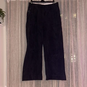Grå byxor från H&M - Säljer ett par grå byxor från H&M i storlek 42. De har en klassisk design med en vid, rak passform, hög midjaoch är tillverkade i ett bekvämt material. Breda fållar längst ner på byxbenen. Perfekta för både vardag och fest! Färgen är typ ”urtvättad svart”, inte så mörk som på de första bilderna och inte så ljus som på de sista. Svår att fånga på bild. 