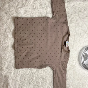 Brun prickig tröja från Kaxs - Säljer en söt brun prickig tröja från Kaxs i storlek 74/80. Den har långa ärmar och knappar vid halsen för enkel påklädning. Perfekt för både höst och vår! 🐻fint skick! 