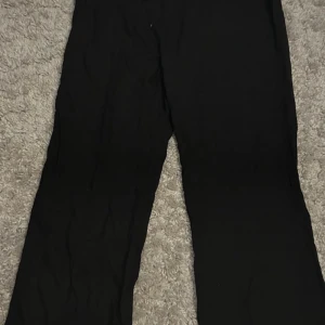 Linnebyxa - Säljer ett par bekväma svarta byxor. De har en loose passform och är perfekta för en avslappnad stil. Byxorna har en elastisk midja för extra komfort.