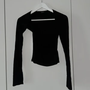 Svart topp från Gina tricot - Svart topp från Gina tricot med bandaue inspiration i storlek Xs