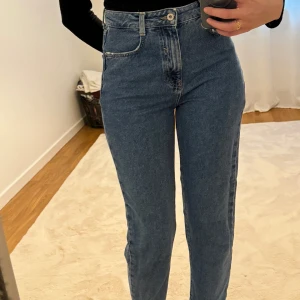Blå jeans från Zara - Säljer ett par snygga blå jeans från Zara i storlek 36. De är högmidjade och i mom modell. 