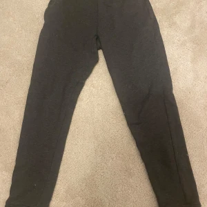 Svarta mjukisbyxor från Adidas - Säljer ett par svarta mjukisbyxor från Adidas i herrstorlek M. De är i helt okej skick och perfekta för träning eller en chill dag hemma. Byxorna har en elastisk midja för extra komfort. Passar perfekt till höst och vinter!