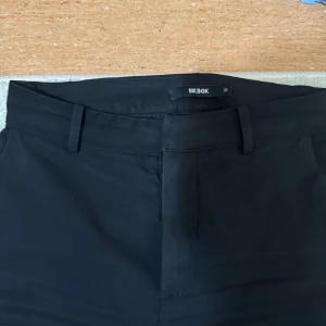 Svarta kostymbyxor från Bik Bok - Snygga svarta byxor från Bik Bok i storlek 36. De har en klassisk design med raka ben.