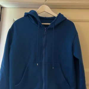 Blå hoodie med dragkedja -  Blå hoodie i bra skick. Har huva med snören. Perfekt för kyliga dagar, Storleken är normal. Passar både xs/s.