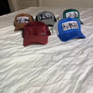 Maggiore kepsar - Säljer ett gäng kepsar från märket maggiore i olika färger och med coola tryck på framsidan. Perfekta för att ge din outfit en unik touch. Kepsarna har nät på baksidan för bra ventilation och justerbar passform. Färgerna inkluderar vinröd, blå, grön, brun och grå. Passar perfekt för både vardag och fest! Säljer dom för 300 styck kan gå ner i pris om man köper flera 