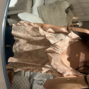 Rosa blommig linne Zara - Säljer ett superfint rosalinne med blommigt mönster från Zara. Toppen har volangdetaljer och är ärmlös, perfekt för sommardagar eller en festkväll. Materialet är lätt och luftigt, vilket gör den bekväm att bära. Passar perfekt till jeans eller kjol! Nyskick utan prislapp.