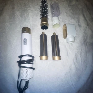 Hårstyler  - Multifunktionell hårstyler med flera utbytbara tillbehör, inklusive rundborste och locktillbehör. Perfekt för att skapa olika frisyrer med volym och lockar. Vit och guld design med sladd ❣️