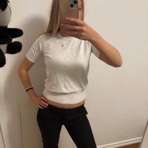 Vit kortärmad topp - Säljer en stilren vit topp i bomull med korta ärmar. Perfekt för vardagsbruk eller att klä upp med accessoarer. Toppen har en normal passform och är superbekväm. Passar till både jeans och kjol!
