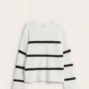 Vit och svart randig tröja - Mysig vit tröja med svarta ränder. Perfekt för kyliga dagar med sin fluffiga och mjuka textur. Den har en avslappnad passform och långa ärmar, vilket gör den idealisk för både vardag och mysiga hemmakvällar.