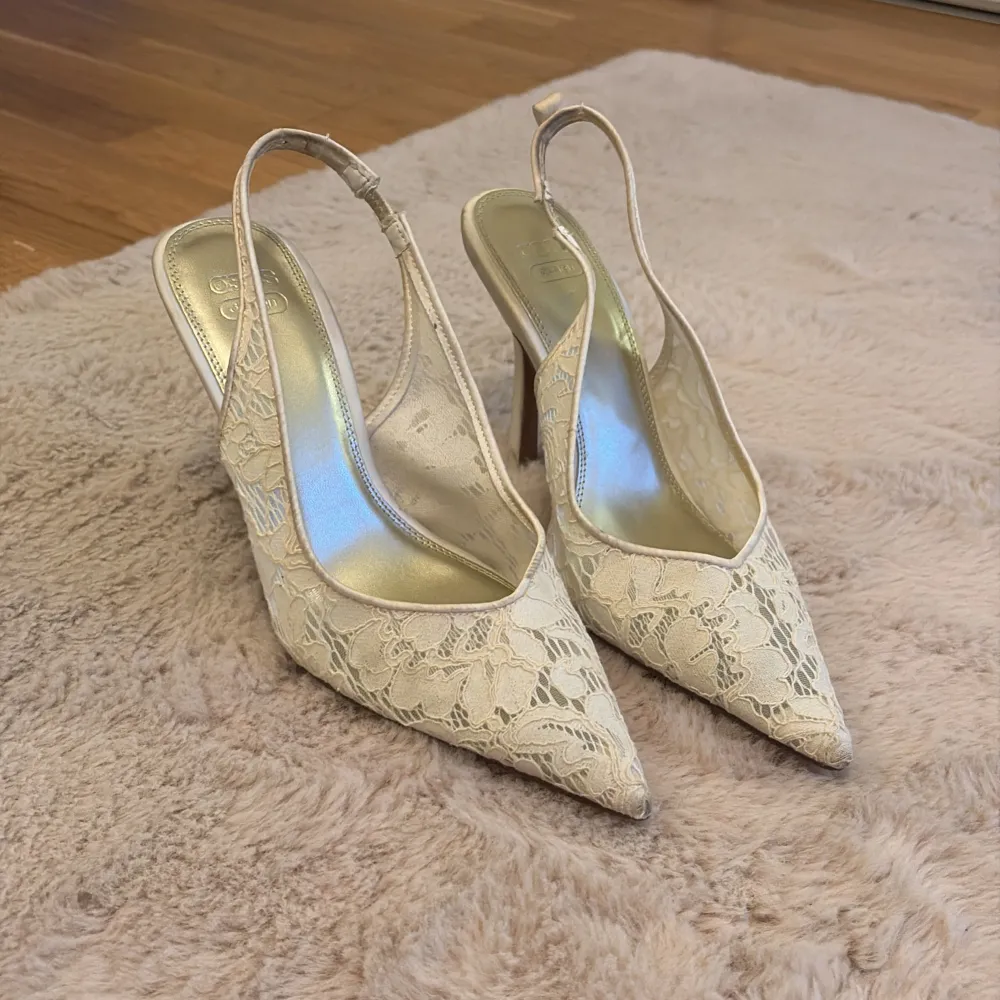 Snygga beige pumps med spetsig tå och spetsdetaljer. Perfekta för fest eller bal, dessa skor har en elegant design med en liten klack. De är i mycket bra skick och passar perfekt till en somrig eller vårig outfit.. Skor.