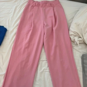 Rosa byxor - Säljer ett par snygga rosa byxor i loose fit. De är högmidjade och har en stilren design utan mönster. Perfekta för både vardag och fest! 💖