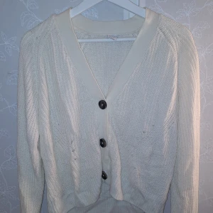 Vit stickad kofta  - Säljer en superfin vit stickad kofta från Lindex i storlek 158/164. Den har stora knappar framtill och är perfekt för både höst och vår. Koftan är i bra skick och passar perfekt för att hålla sig varm och stilren. Perfekt för lager-på-lager-look!✨Vill även tillägga att den är som en xs från dam avdelningen😊🩷