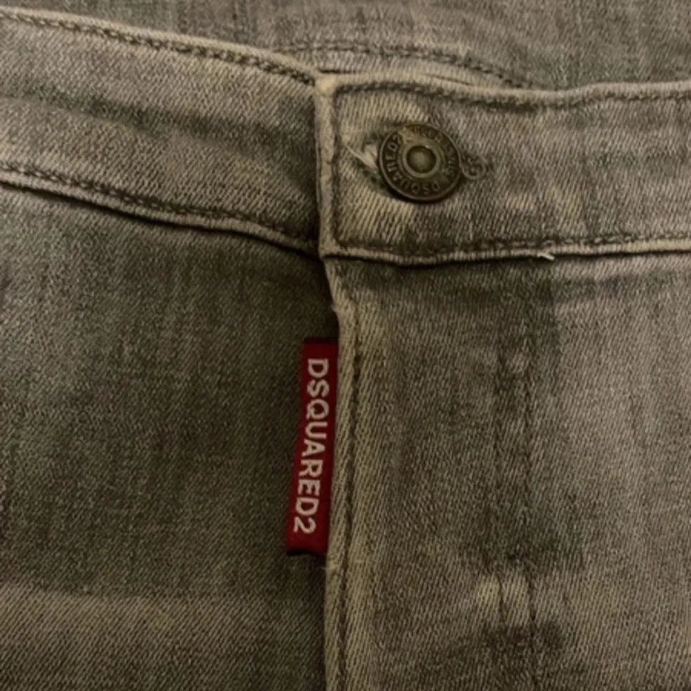 Säljer ett par grå jeans från Dsquared2 i bra skick. De har en cool, sliten look med detaljer som revor och en unik fickdesign. Perfekta för en avslappnad stil med en touch av edge. Passar bra till både vardag och fest!. Jeans & Byxor.