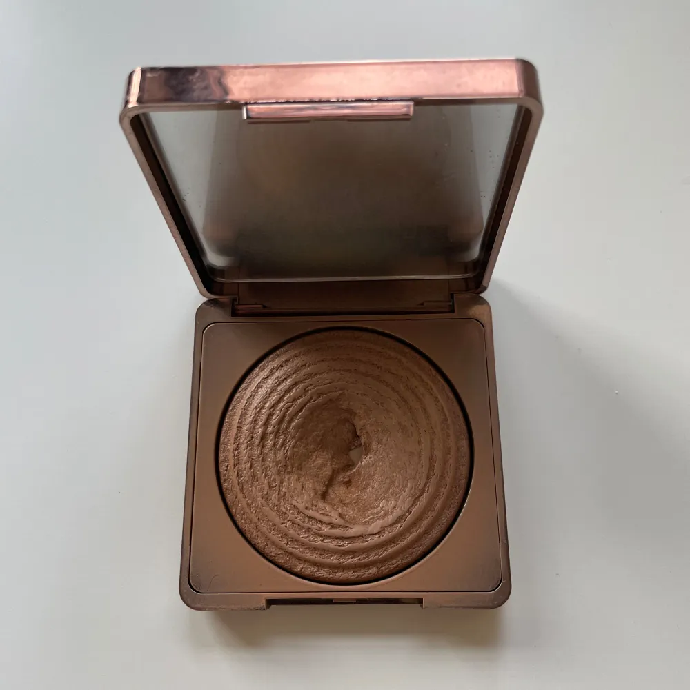 Snygg bronzer i en stilren, fyrkantig förpackning med roséguldfärgad finish. Perfekt för att ge ansiktet en solkysst look med en subtil glöd. Den har en vacker, vågig textur som gör appliceringen jämn och enkel.. Skönhet.