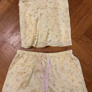 Söt pyjamas  - Super söt gul pyjamas med små blommor på i silkes😍 aldrig använd!❤️