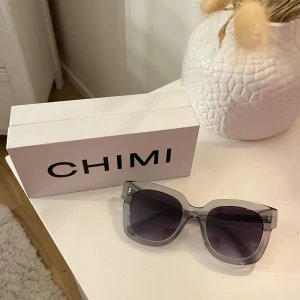 Grå solglasögon från CHIMI - Säljer ett par snygga grå solglasögon från CHIMI i mycket bra skick. De har en stilren design med transparenta bågar och mörka glas. Inga defekter däremot saknas förvaringsfodralet. Kommer med originalförpackning och förvaringspåse!💓💌