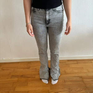Grå jeans från Zara - Säljer ett par snygga grå jeans från Zara i storlek EUR 36. De har en cool tvättad look och är högmidjade med en bootcut passform med slittar längst ner. Perfekta för både vardag och fest! 🖤