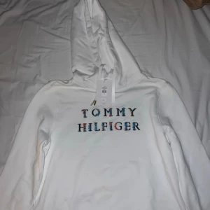 Vit hoodie med blommor Tommy Hilfiger - Helt nytt skick med prislapp på och är i storlek XS. Kan sänka pris ba skicka förslag