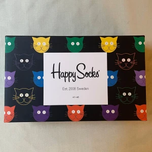 KATT STRUMPOR - Säljer tre par unisex katt strumpor från Happy Socks.  Strumporna är i nyskick och har en skön passform.