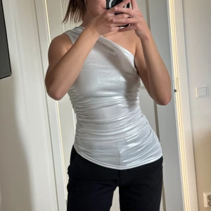 One shoulder - topp  - Snygg silvrig topp från H&M.  Oanvänd! Storlek XS