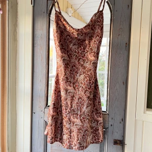 Paisleymönstrad klänning - Aldrig använd, endas provad, köpt för ett par år sedan. Fint skick med en liten sömdefekt som syns på bild 3 och 4 och går enkelt att justera😄 bra längd på mig som är 165.