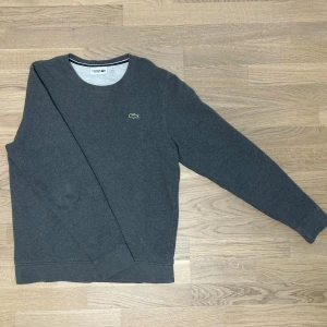 Lacoste Crewneck - Skön tjocktröja från Lacoste, perfekt för kylan. Den är stilren och i mycket bra skick. Storlek M men sitter mer som en S enligt oss. Modellen är 183cm och väger 75kg. Vid eventuella funderingar så är det bara att höra av sig!