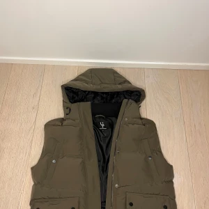 Hooded puffer vest - Only has been tried on. Very comfortable, thick and warm. It is also water and -wind resistant.