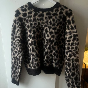 Stickad leopard tröja  - Stickad tröja med leopardmönster från NA-KD. Köpt på vinted men endast använd en gång av mig och den är i jättefint skick. Strl M, passar även S och L beroende på hur man vill att den ska sitta💕
