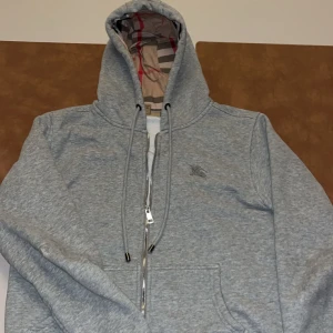 Grå burberry zip - Grå burberry zip up tröja Storlek M Gott skick förutom en liten slitning på höger armbåge