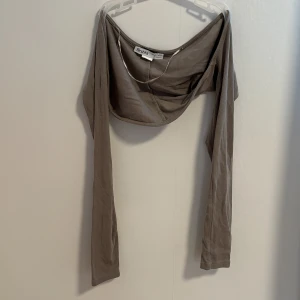 Grå bolerotopp från Bershka - Säljer en grå (gråbeige) bolerotopp från Bershka. Den är perfekt över ett linne eller en kortärmad klänning, och har långa ärmar. 