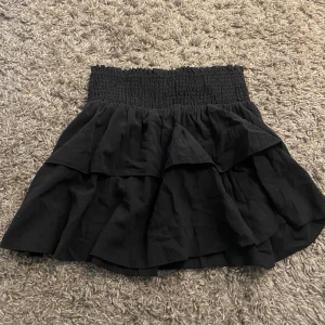 Volang kjol  - Svart volangkjol, funkar till sommar/vår men också till vinter/höst med ett par leggings under. 