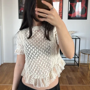 Vit spetsblus med volangdetaljer Zara  - Säljer en superfin beige spetsblus från Zara med korta ärmar och volangdetaljer i nederkant. Blusen är croppad och har ett fint mönster som ger en somrig känsla. Perfekt för sommarens fester eller en dag på stan💓 Använd endast några enstaka gånger.