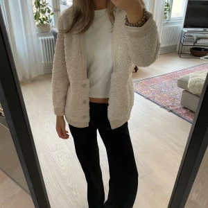 Superfin jacka  - Säljer denna superfina jacka då den ej kommer till användning längre. Den är vändbar och är lite teddyliknande i materialet. Jag skulle säga att den är varm och den går att knäppa vid magen. Den är benvit/ljust beige.
