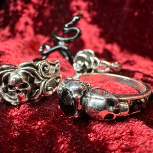 Fyra nya silverfärgade ringar med dödskalle, orm & rosmotiv Metal Rock Punk Goth Gothic Alternativ Halloween Bundlerabatt  - Säljer ett set med fyra feta matchande ringar. Två med detaljerade dödskallar & intrikata mönster, en m gnistrande strass, en vacker ros & svart slingrande orm. 1,6-1,85 innerdiameter. Höjd 3,5-0,9. Säljs som set. Stål/ metallegering. Färdigprutade.