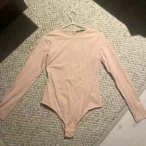 Body - Ljus rosa body med öppen rygg från GinaTricot. Använt endast en gång.