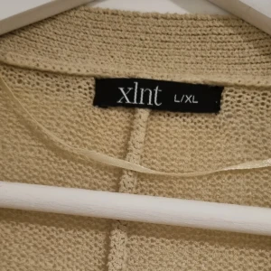 Beige stickad kofta från xlnt - Säljer en supermysig beige stickad kofta från xlnt. Perfekt för kyliga höst- och vinterdagar. Den har en öppen design utan knappar och långa ärmar, vilket gör den både bekväm och stilren. Passar perfekt för en avslappnad look eller att mysa i hemma. 🧥✨