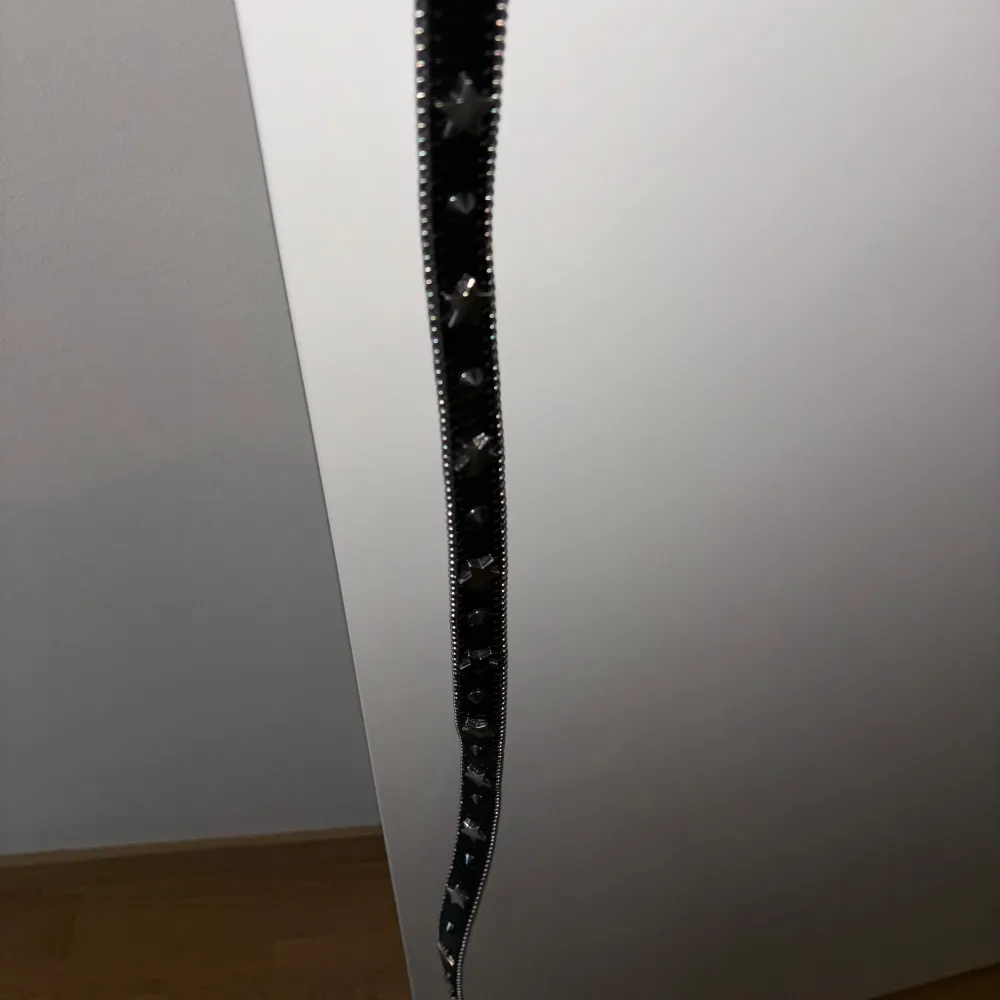 Snyggt svart bälte från Topshop med ett detaljerat, silverfärgat spänne. Bältet har en rad med små nitar längs kanterna som ger det en extra touch. Perfekt för att ge din outfit lite edge.. Muu.