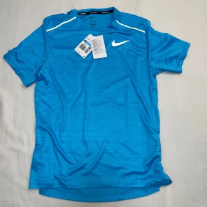 Nike Miler T-Shirt - Säljer en jättesnygg Nike Miler T-Shirt som är perfekt för sommaren och för träning. Den är helt ny och har absolut inga skador eller liknande.