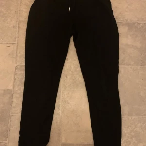 Svarta mjukisbyxor från Esmara - Svarta mjukisbyxor från Esmara med elastisk midja och snörning. Perfekta för en avslappnad stil och bekväma att bära. Passar bra för hemmamys eller en lugn dag ute.